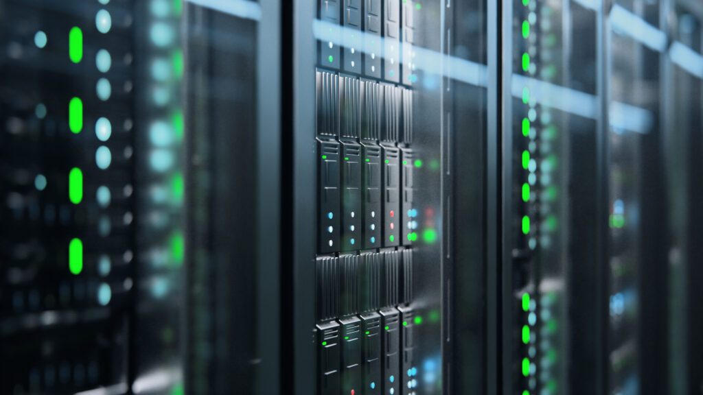 Nahaufnahme eines modernen Serverschranks in einem Rechenzentrum, der sich ideal für das Hosting von Cloud-Servern eignet. Auf den glatten Metall- und Glasoberflächen spiegeln sich Reihen von Servern und grün und blau beleuchtete Anzeigeleuchten.